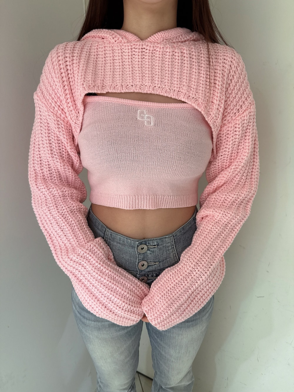 ブルー系のデニムパンツ、ピンク系のニット/セーター、ブラック系のブーツを着用したレディースの冬コーディネートの7枚目の写真