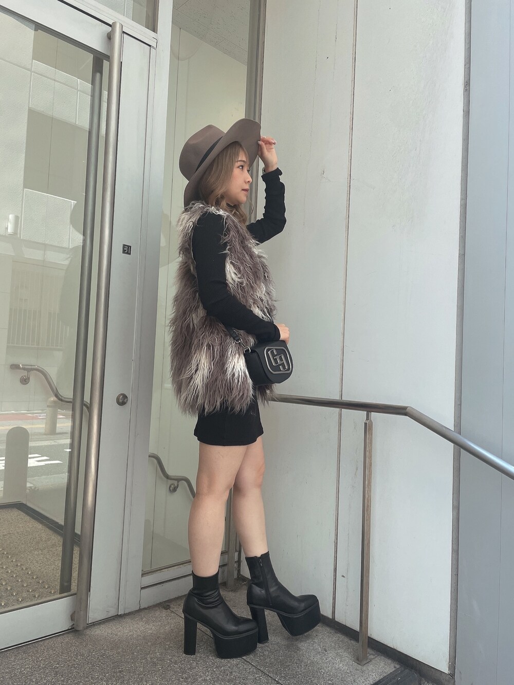 ブラック系のワンピース、その他のベスト、ブラック系のハンドバッグを着用したレディースの秋コーディネートの3枚目の写真