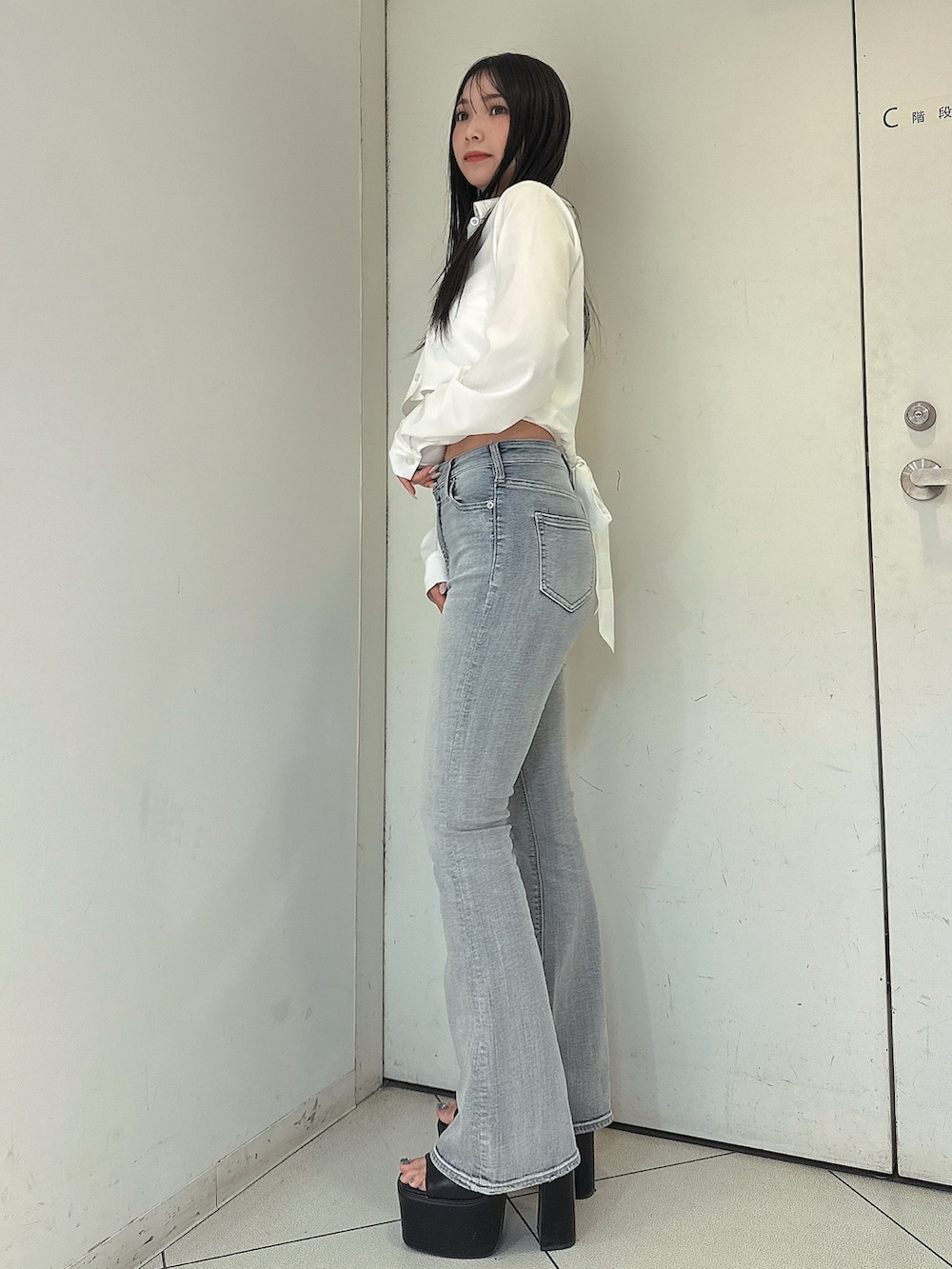 ブルー系のデニムパンツ、ホワイト系のキャミソール、ホワイト系のシャツ/ブラウスを着用したレディースの春コーディネートの2枚目の写真