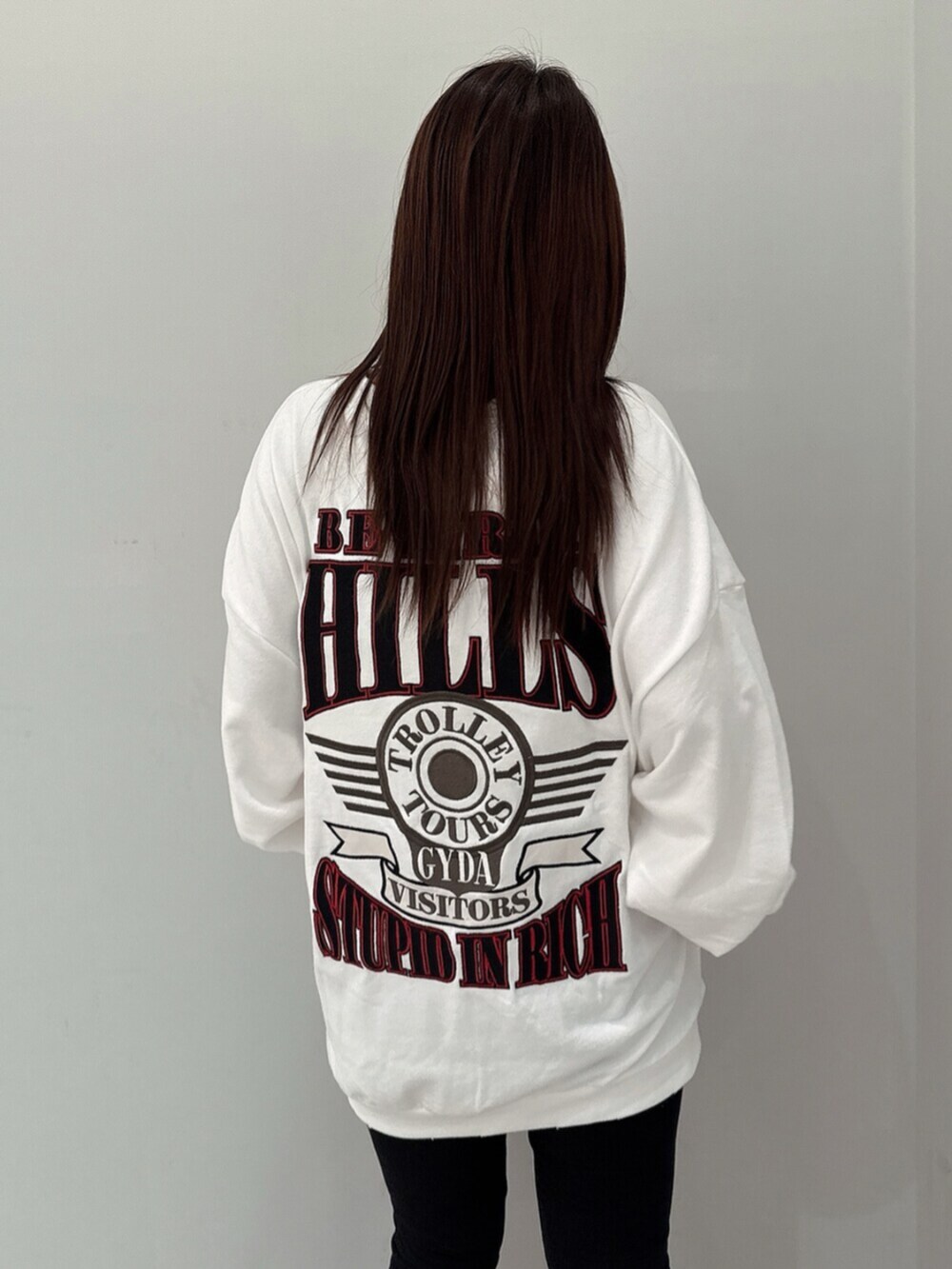 ブラック系のデニムパンツ、ホワイト系のスウェット、ブラック系のブーツを着用したレディースの夏コーディネートの6枚目の写真