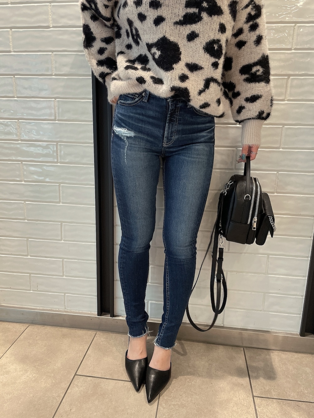 ホワイト系のTシャツ/カットソー、ホワイト系のバックパック/リュック、ブルー系のデニムパンツを着用したレディースの冬コーディネートの8枚目の写真