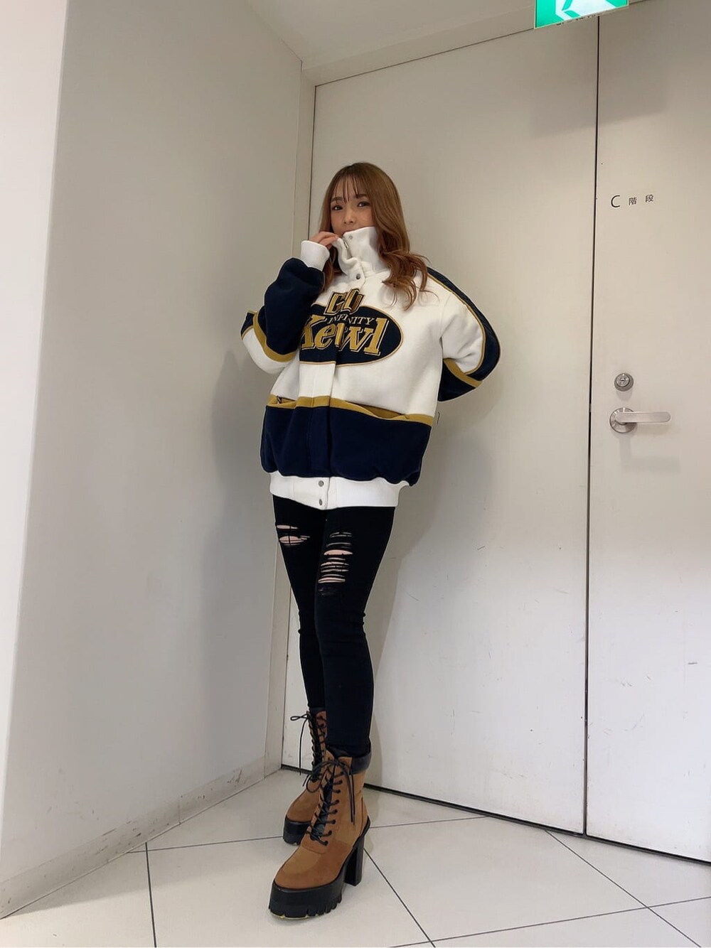 ブラック系のデニムパンツ、ブラック系のデニムパンツ、ホワイト系のブルゾンを着用したレディースの秋コーディネートの3枚目の写真