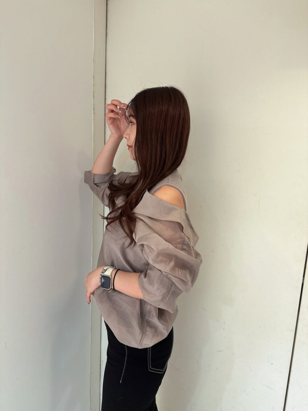 ブラック系のデニムパンツ、ブラック系のサンダル、ベージュ系のシャツ/ブラウスを着用したレディースの春コーディネートの5枚目の写真