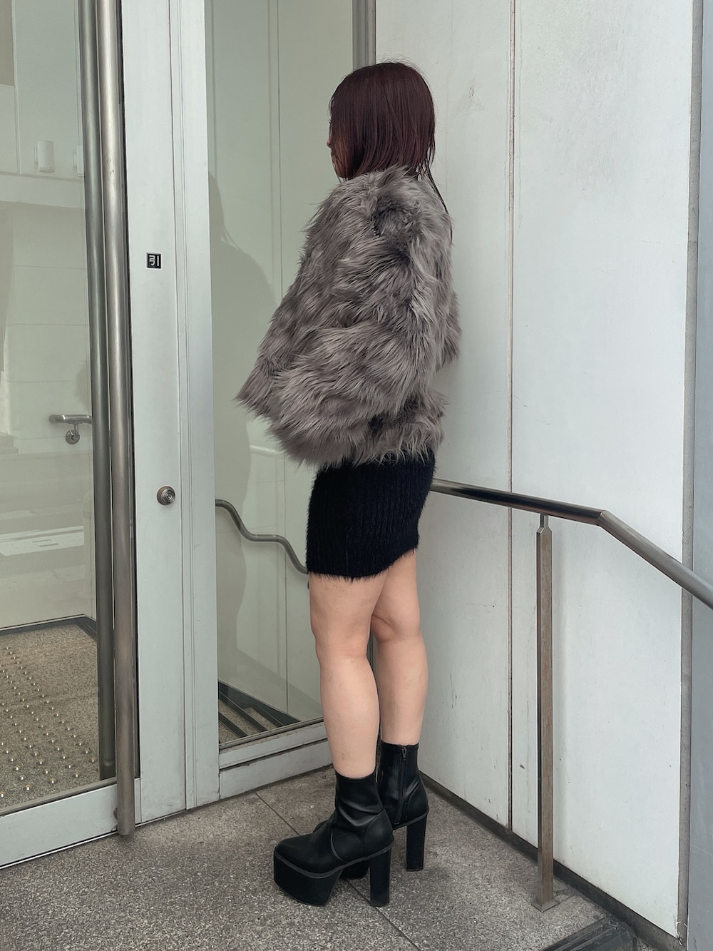 ブラック系のブーツ、ブラック系のワンピース、グレー系のライダースジャケットを着用したレディースの秋コーディネートの2枚目の写真