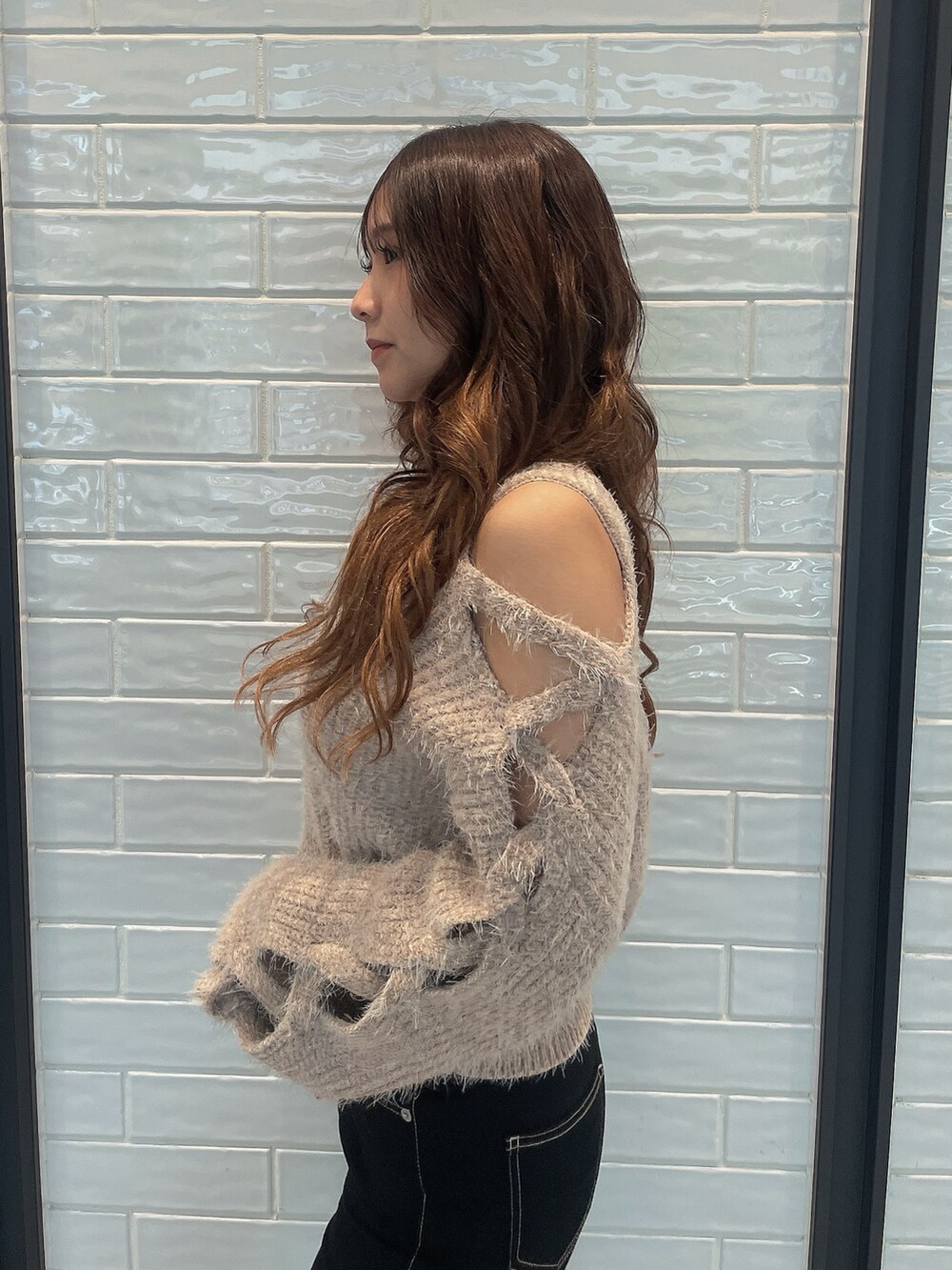 ベージュ系のニット/セーター、ブラック系のデニムパンツ、ブラック系のブーツを着用したレディースの秋コーディネートの5枚目の写真