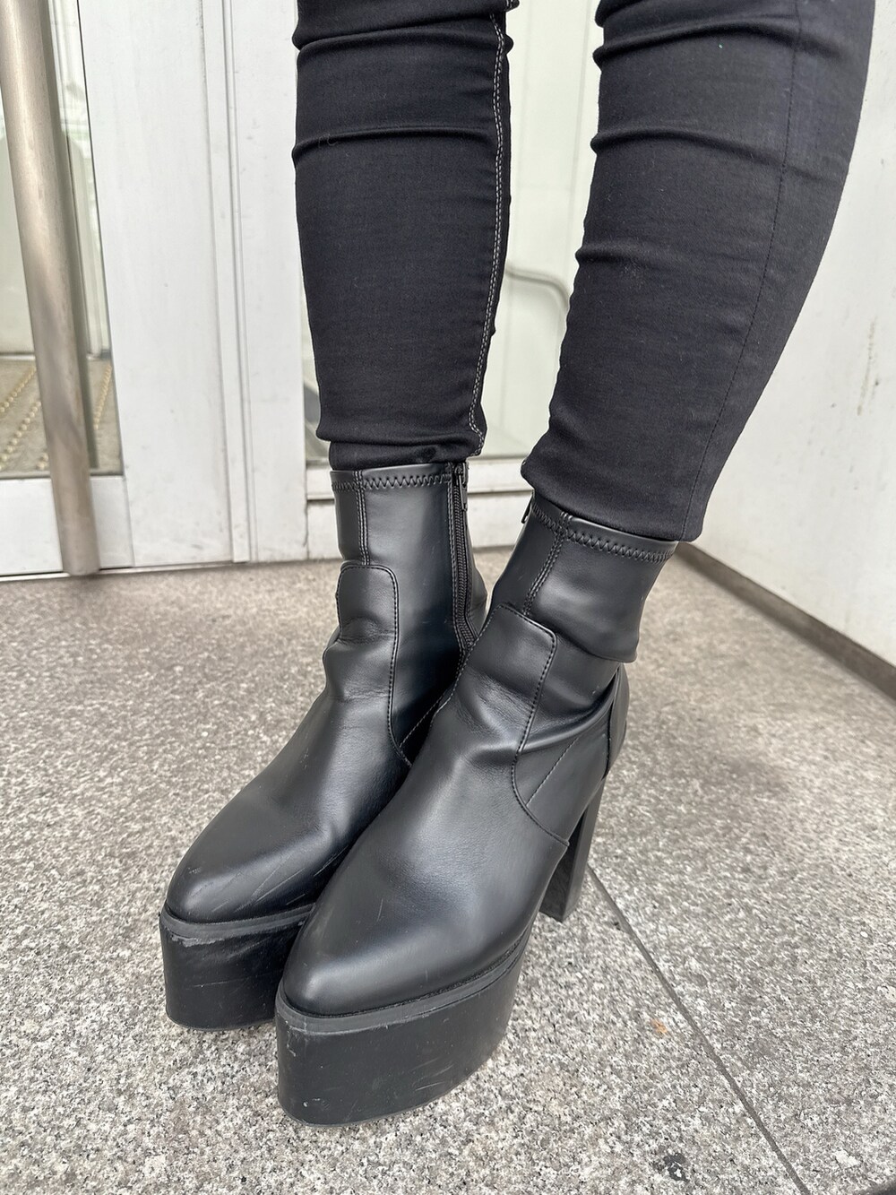 ホワイト系のスウェット、ブルー系のデニムパンツ、ブラック系のブーツを着用したレディースの秋コーディネートの8枚目の写真