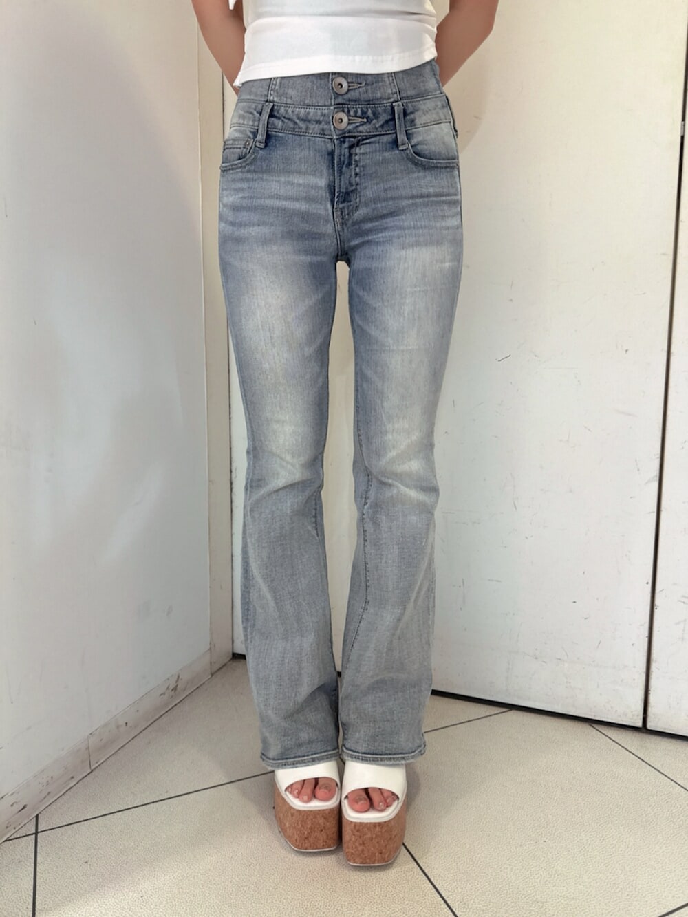 ブルー系のデニムパンツ、ホワイト系のサンダル、ホワイト系のチューブトップを着用したレディースの夏コーディネートの8枚目の写真