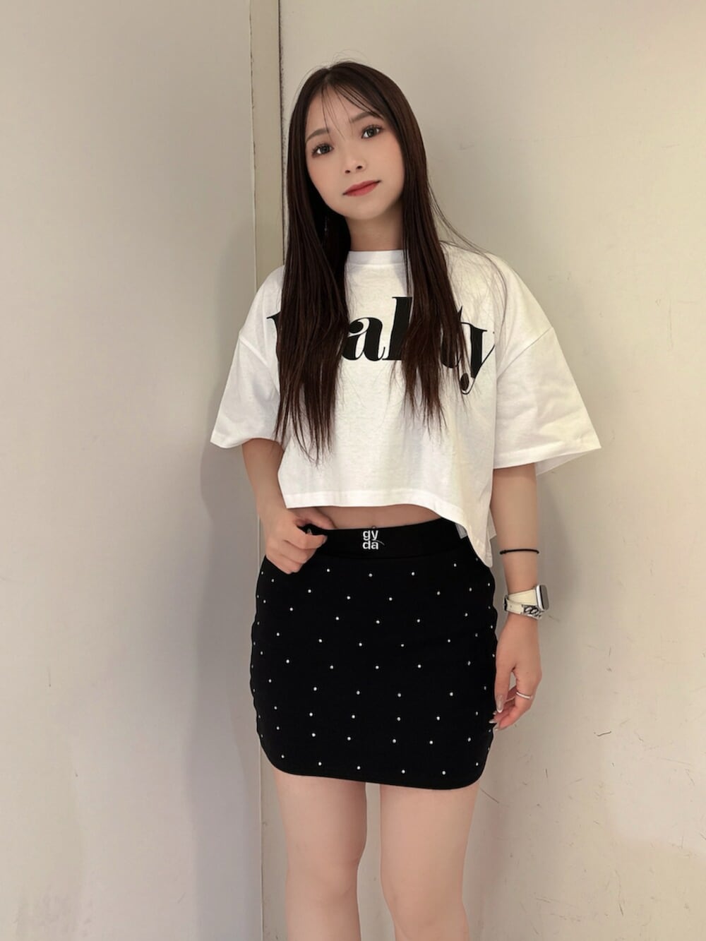 ブラック系のスカート、ホワイト系のTシャツ/カットソー、ブラック系のサンダルを着用したレディースの夏コーディネートの4枚目の写真