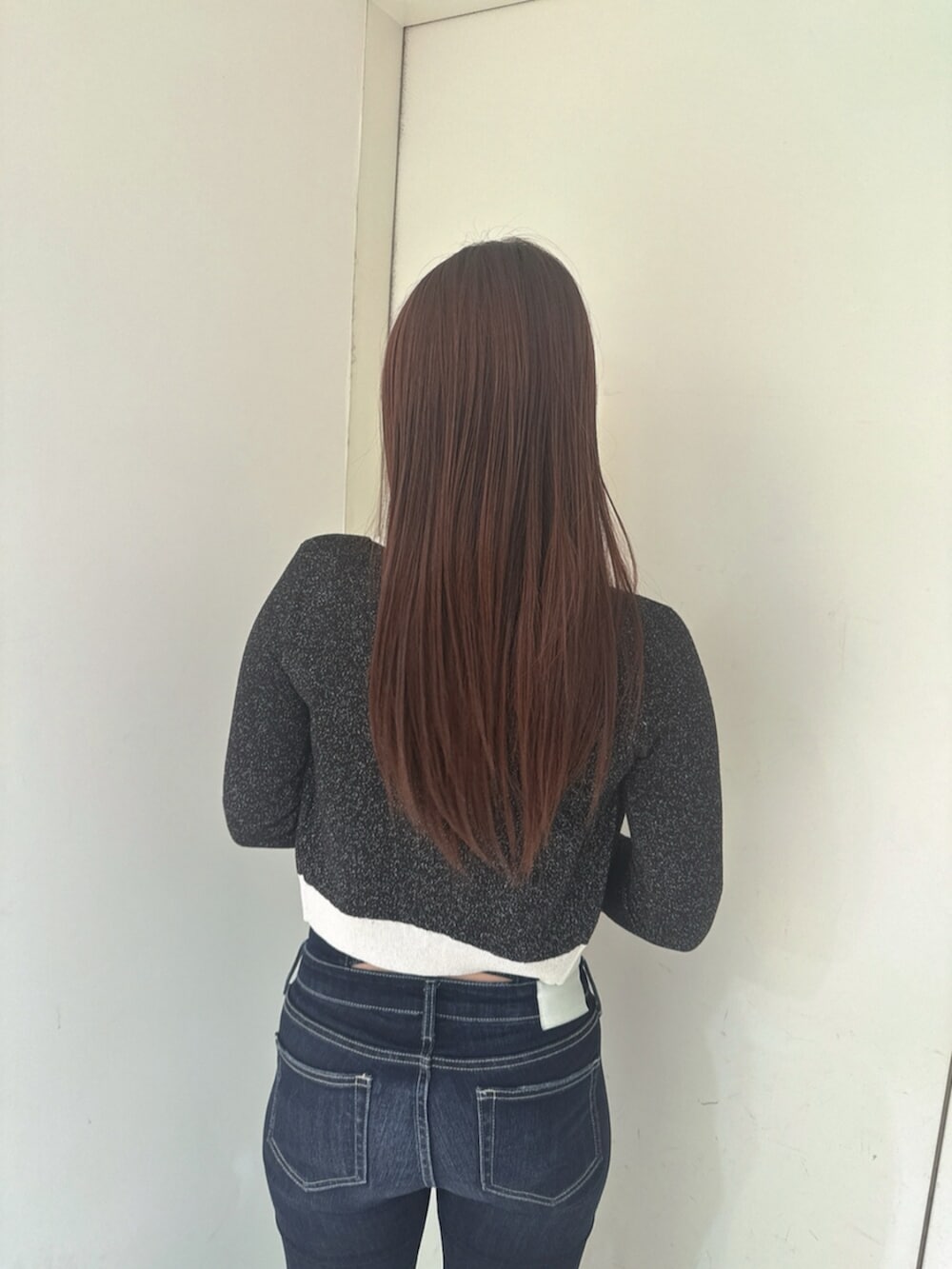 ブルー系のデニムパンツ、ブラック系のサンダル、ブラック系のニット/セーターを着用したレディースの春コーディネートの6枚目の写真