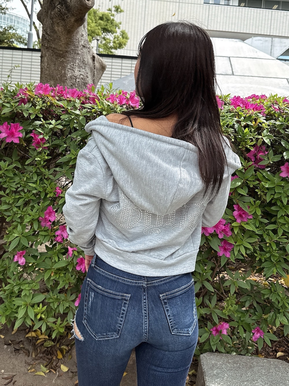 グレー系のパーカー、ブルー系のデニムパンツ、ホワイト系のサンダルを着用したレディースの春コーディネートの6枚目の写真