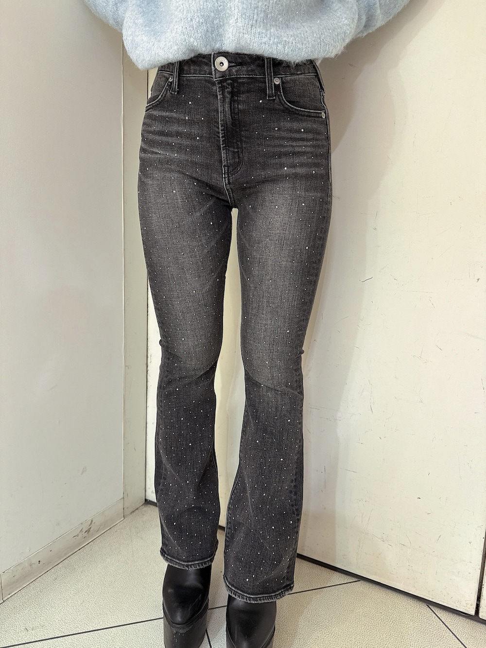 ブラック系のデニムパンツ、ブラック系のブーツ、ホワイト系のニット/セーターを着用したレディースの冬コーディネートの8枚目の写真