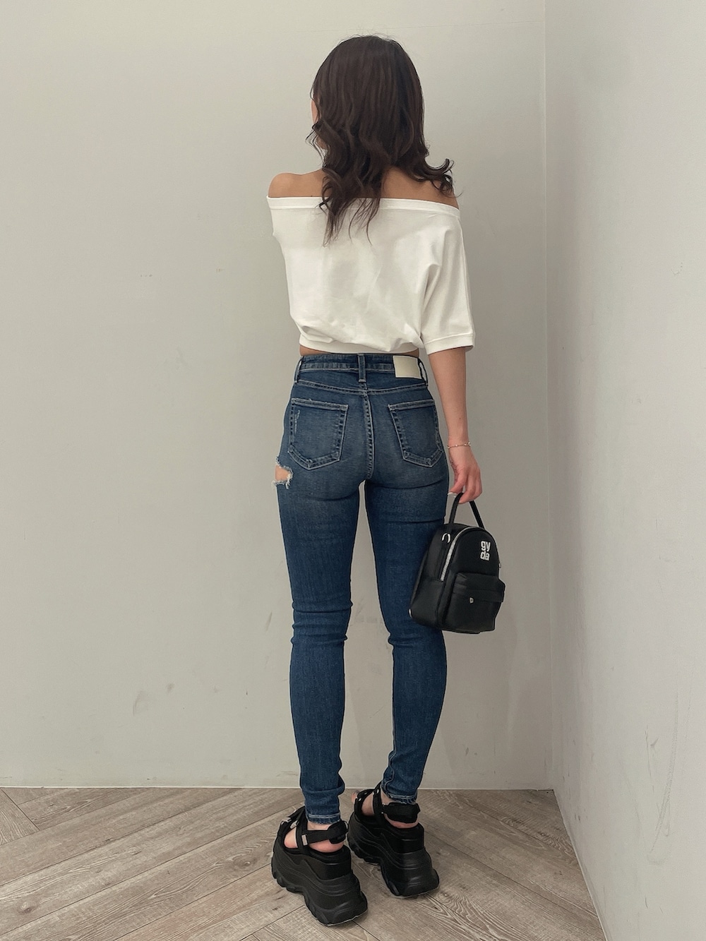 ホワイト系のTシャツ/カットソー、ブルー系のデニムパンツ、ブラック系のバックパック/リュックを着用したレディースの春コーディネートの3枚目の写真