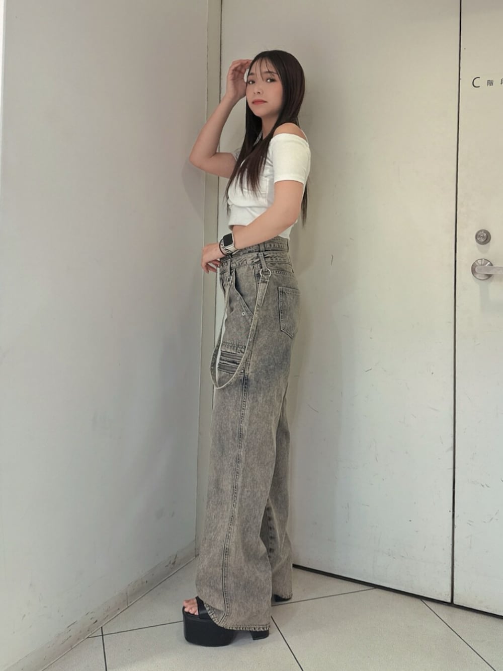 ブラック系のサンダル、ホワイト系のTシャツ/カットソー、ブルー系のデニムパンツを着用したレディースの夏コーディネートの2枚目の写真