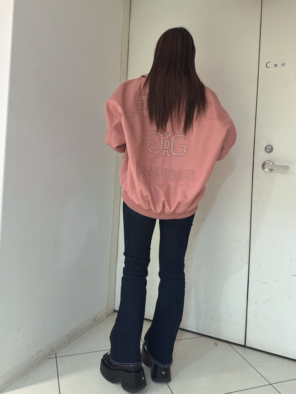 ブルー系のデニムパンツ、ブラック系のサンダル、ピンク系のブルゾンを着用したレディースの春コーディネートの3枚目の写真