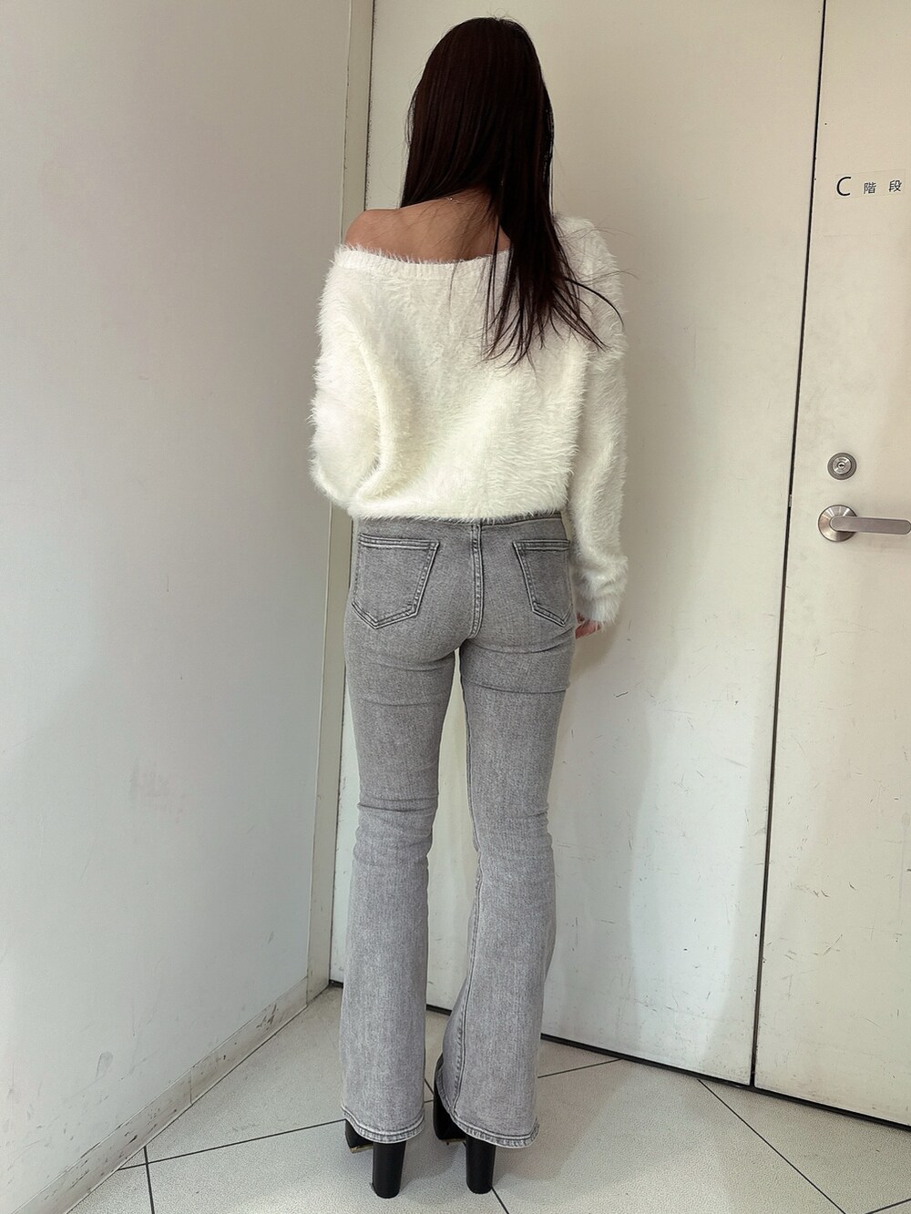 ホワイト系のニット/セーター、グレー系のデニムパンツ、ブラック系のブーツを着用したレディースの冬コーディネートの3枚目の写真