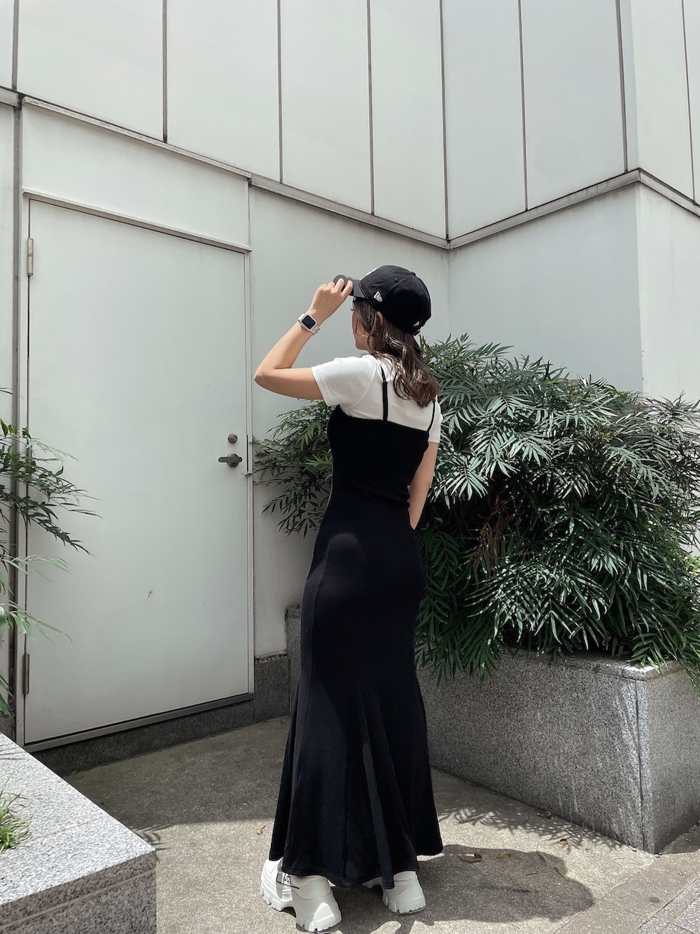 ブラック系のワンピース、ホワイト系のスニーカー、ホワイト系のTシャツ/カットソーを着用したレディースの夏コーディネートの3枚目の写真