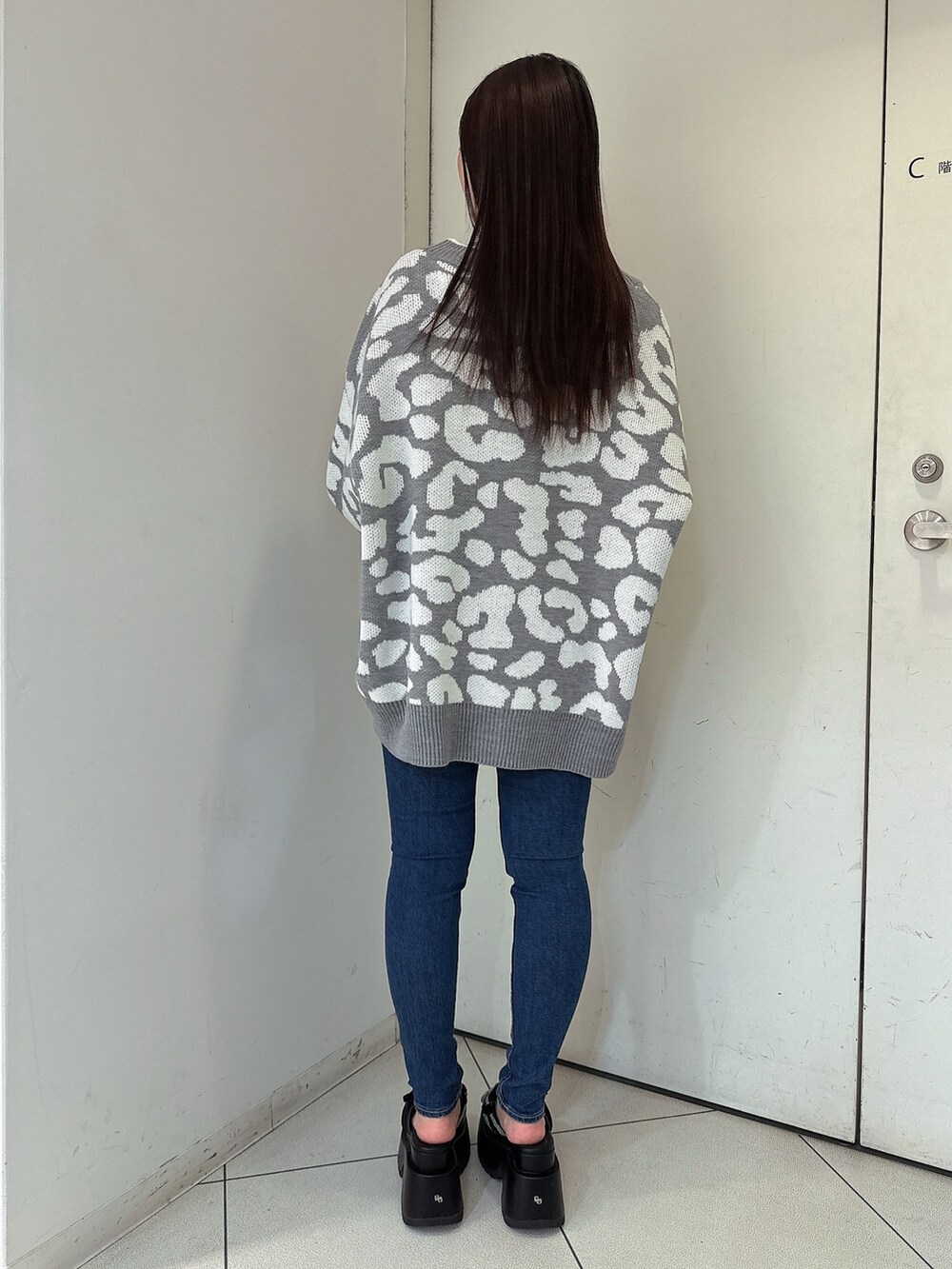 グレー系のカーディガン/ボレロ、ブルー系のデニムパンツ、ブラック系のサンダルを着用したレディースの春コーディネートの3枚目の写真