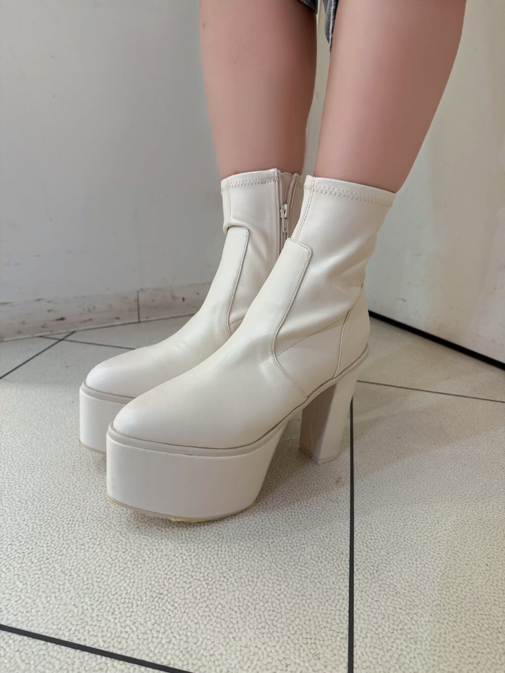 ブルー系のデニムパンツ、ホワイト系のスウェット、ホワイト系のブーツを着用したレディースの夏コーディネートの9枚目の写真
