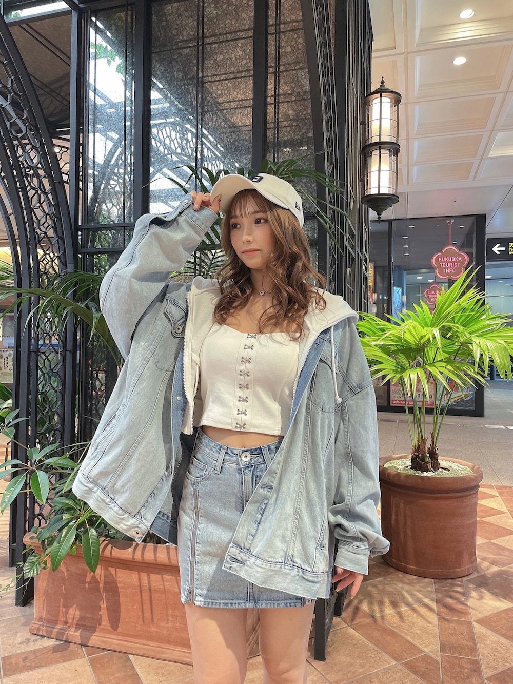 ホワイト系のキャミソール、ホワイト系のパーカー、ブルー系のデニムジャケットを着用したレディースの春コーディネートの3枚目の写真