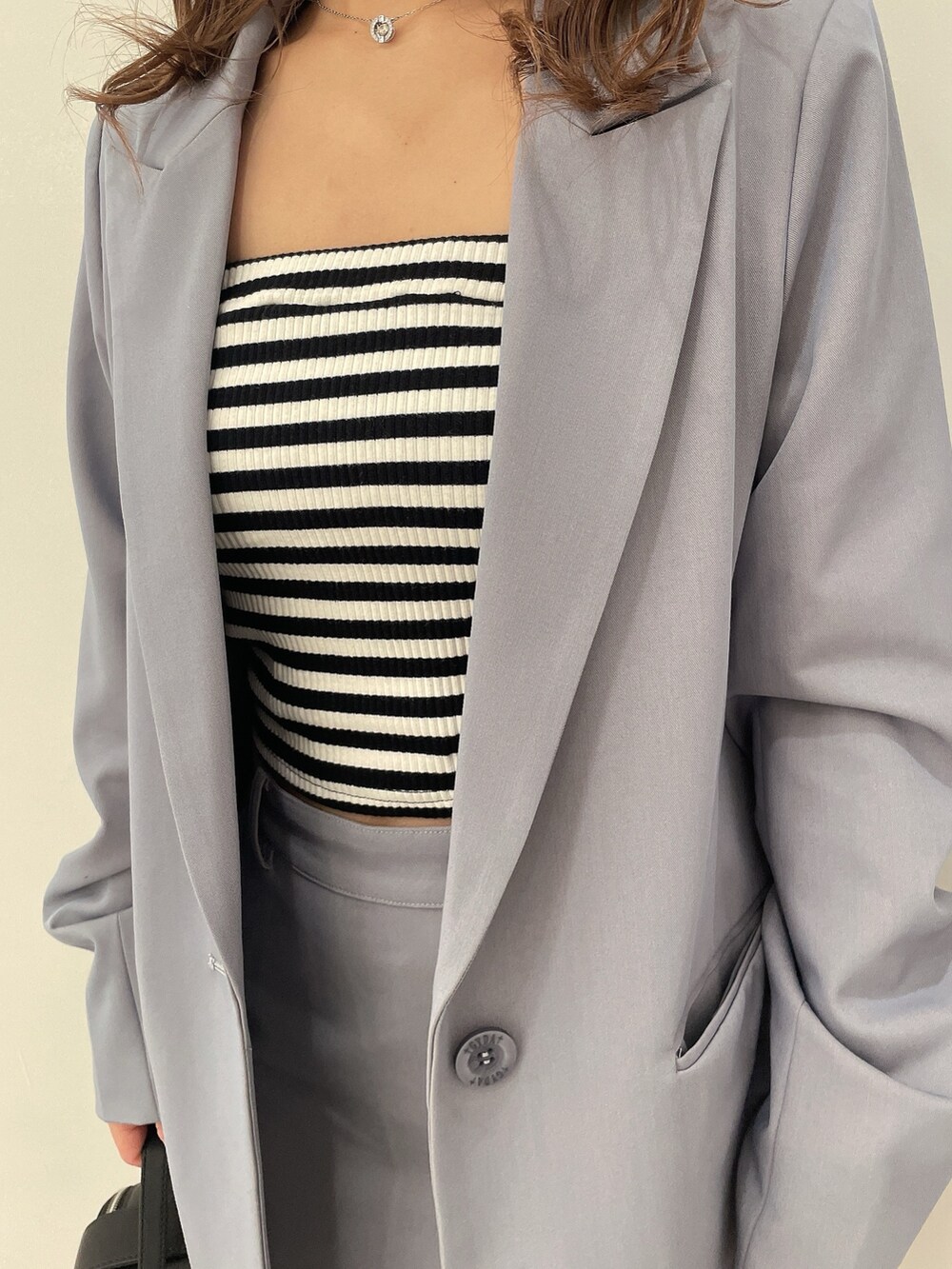 その他のキャミソール、ブルー系のスカート、ブルー系のテーラードジャケットを着用したレディースの春コーディネートの7枚目の写真