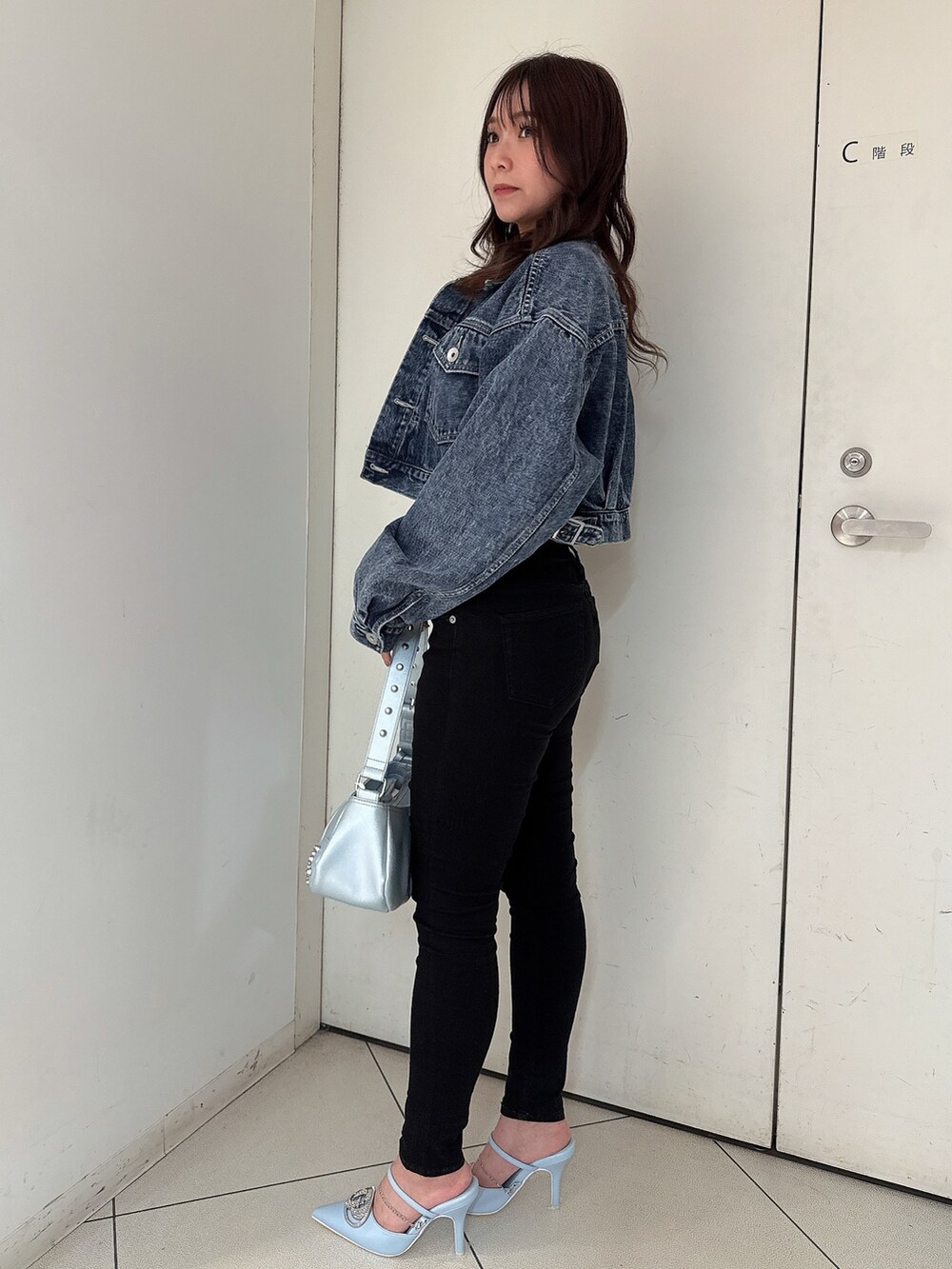 ブラック系のTシャツ/カットソー、ブルー系のデニムジャケット、ブラック系のデニムパンツを着用したレディースの春コーディネートの2枚目の写真