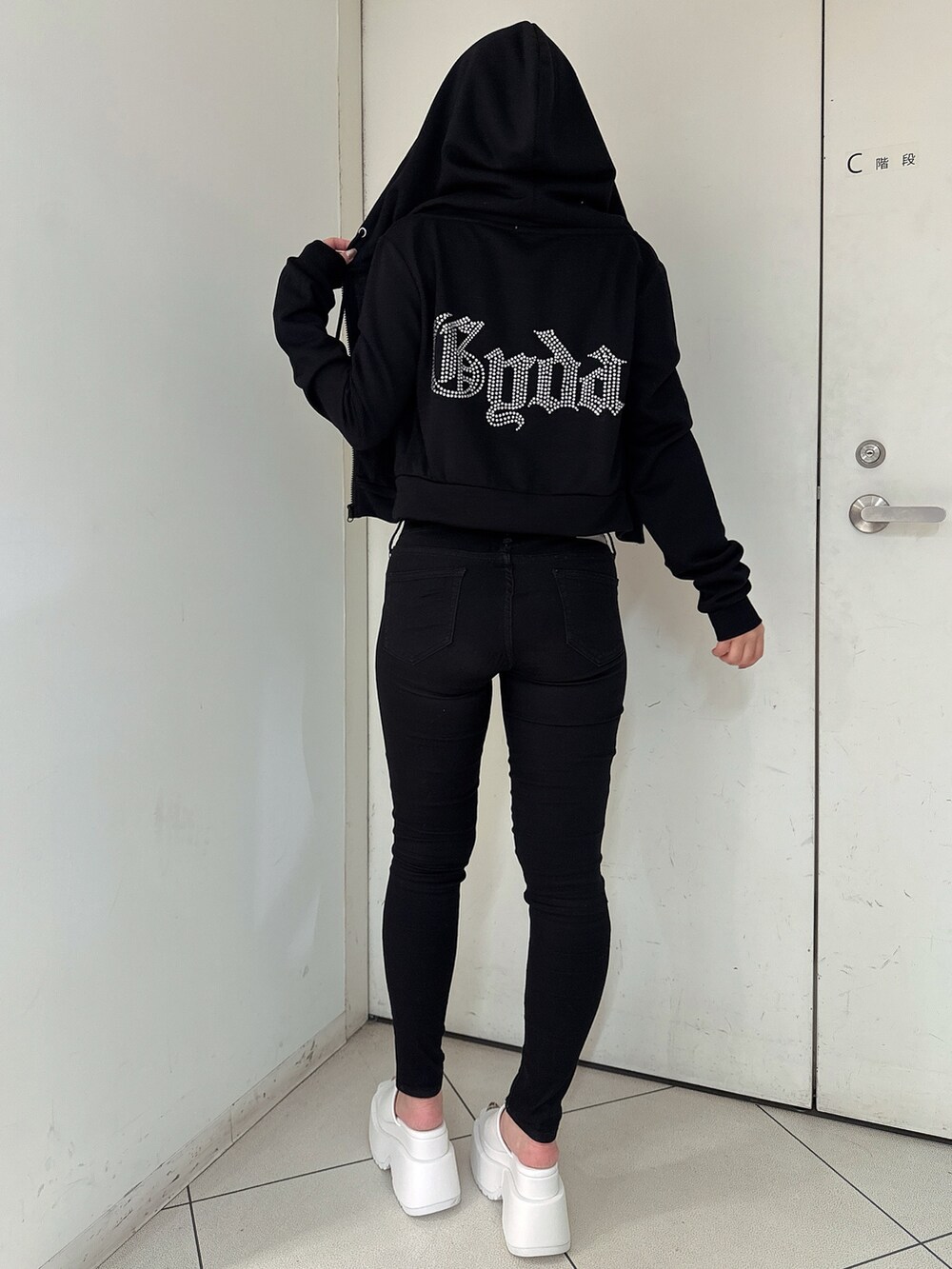 ブラック系のデニムパンツ、ホワイト系のサンダル、ホワイト系のキャミソールを着用したレディースの春コーディネートの3枚目の写真