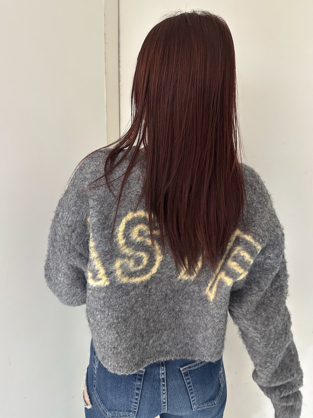 グレー系のカーディガン/ボレロ、ブルー系のデニムパンツ、ブラック系のブーツを着用したレディースの秋コーディネートの6枚目の写真