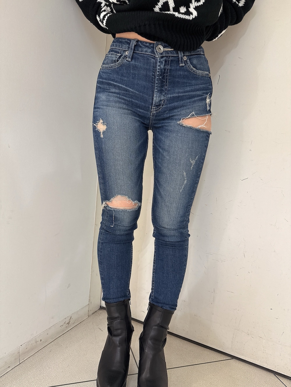 ブラック系のブーツ、ブルー系のデニムパンツ、ブラック系のニット/セーターを着用したレディースの秋コーディネートの8枚目の写真