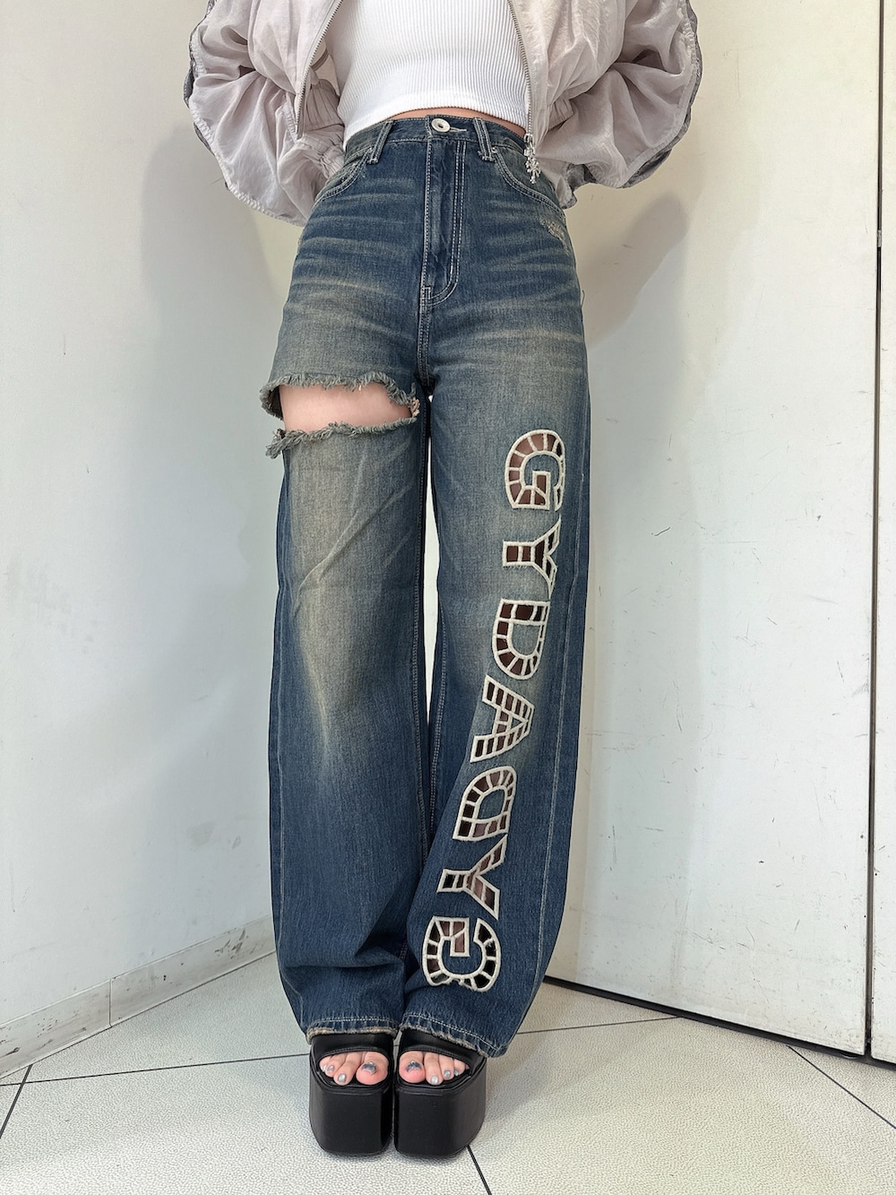 ブルー系のデニムパンツ、ホワイト系のキャミソール、ホワイト系のブルゾンを着用したレディースの春コーディネートの8枚目の写真