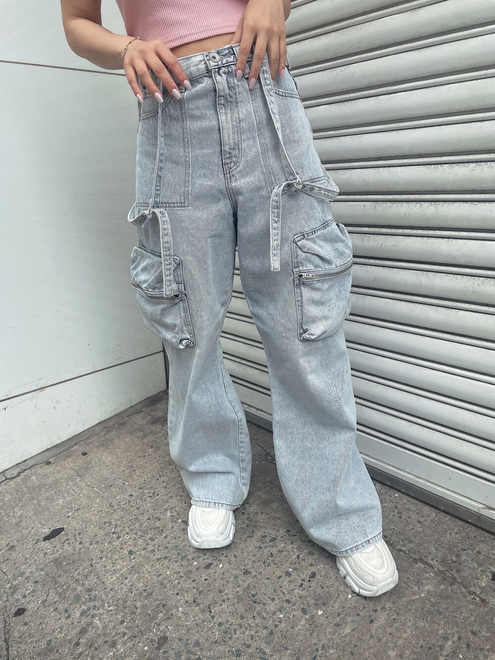 ピンク系のキャミソール、ブルー系のデニムパンツ、ホワイト系のスニーカーを着用したレディースの夏コーディネートの7枚目の写真