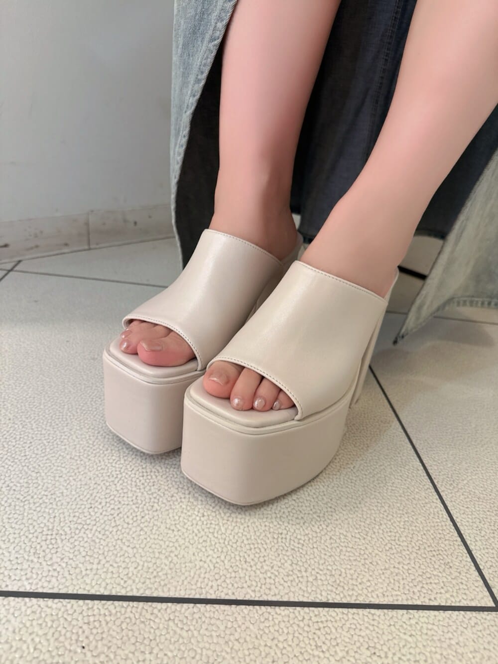 ホワイト系のサンダル、ブルー系のデニムパンツ、ブルー系のTシャツ/カットソーを着用したレディースの夏コーディネートの9枚目の写真