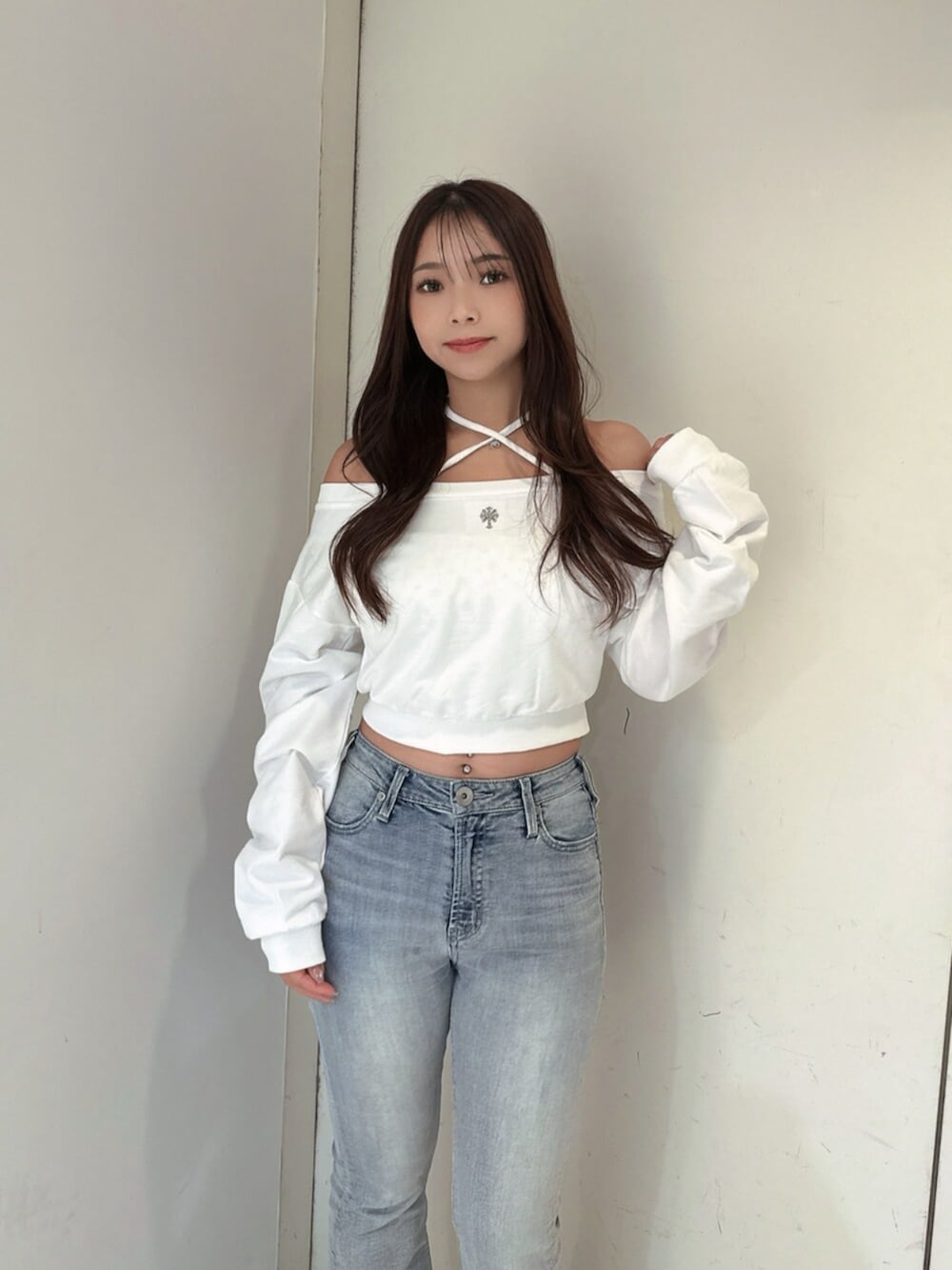ブルー系のデニムパンツ、ホワイト系のスウェット、ホワイト系のブーツを着用したレディースの夏コーディネートの4枚目の写真