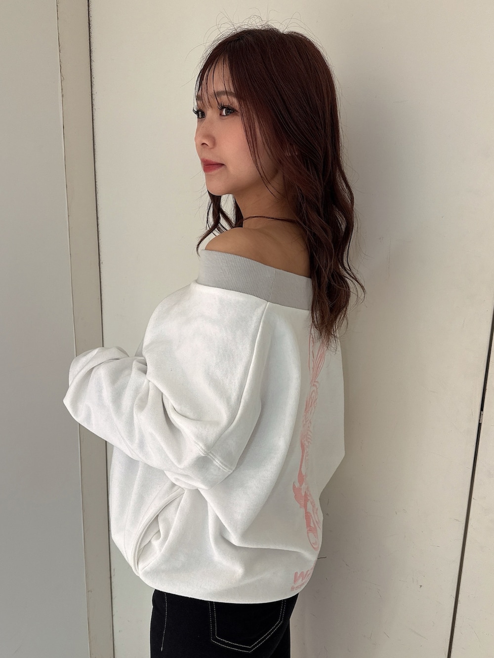 ブラック系のデニムパンツ、ホワイト系のスウェット、ホワイト系のパンプスを着用したレディースの冬コーディネートの5枚目の写真