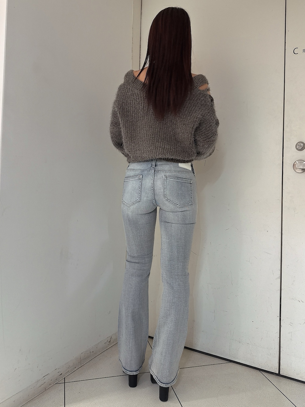 グレー系のニット/セーター、ブルー系のデニムパンツ、ブラック系のブーツを着用したレディースの秋コーディネートの3枚目の写真