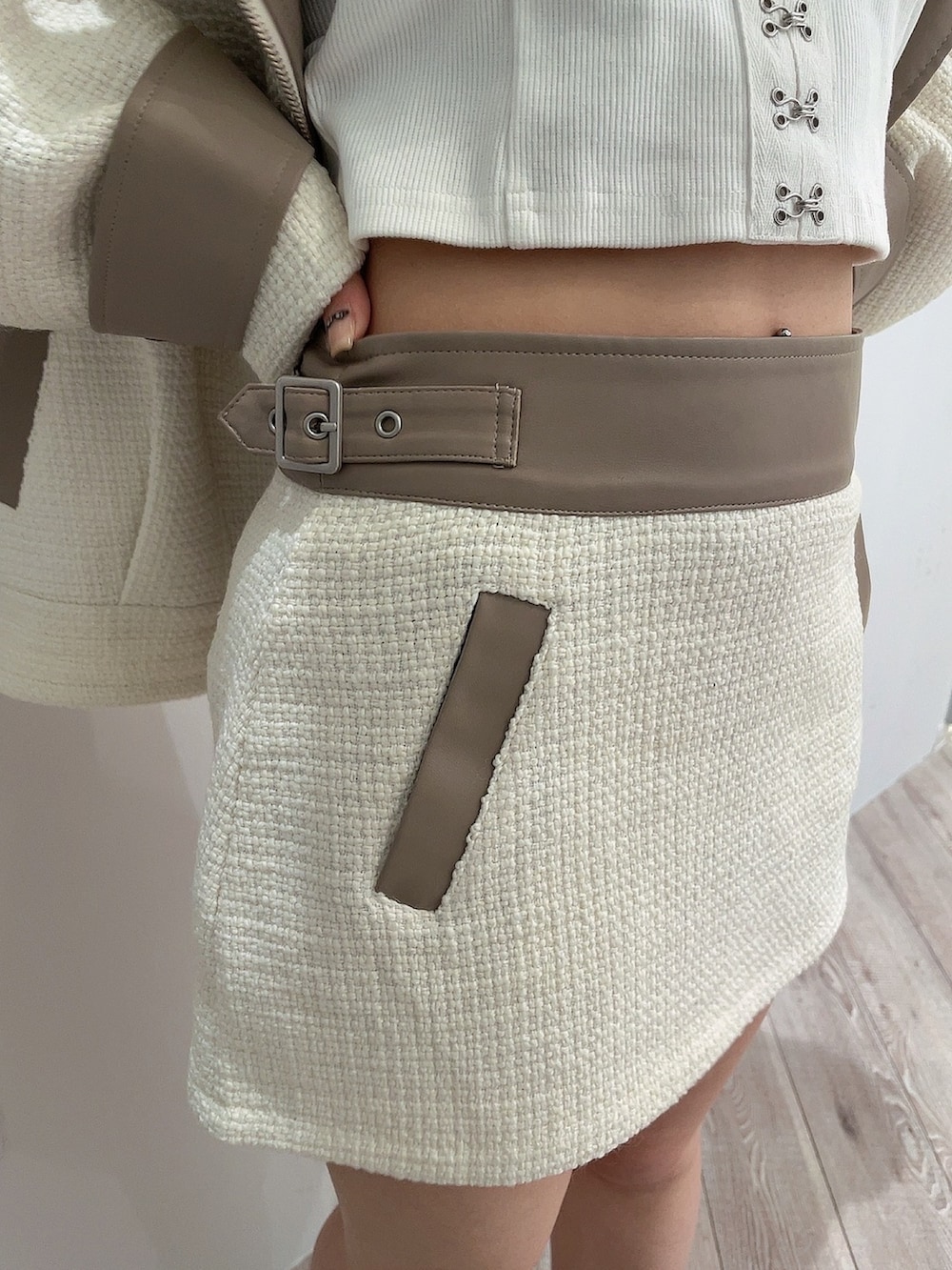 ホワイト系のキャミソール、ホワイト系のライダースジャケット、ホワイト系のスカートを着用したレディースの春コーディネートの8枚目の写真