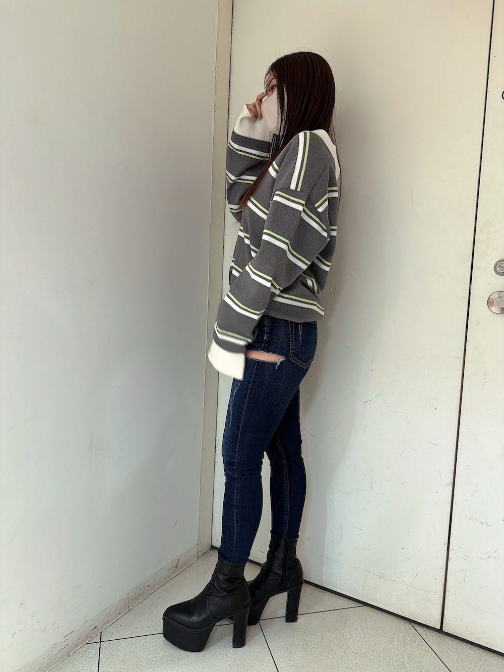 ブラック系のブーツ、ブルー系のデニムパンツ、グレー系のニット/セーターを着用したレディースの冬コーディネートの2枚目の写真