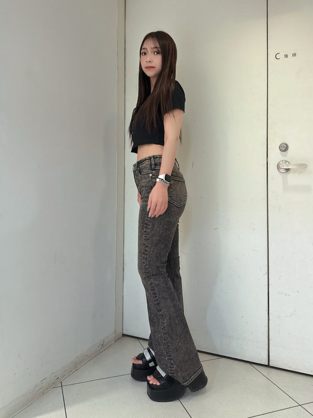 ブラック系のサンダル、ブルー系のデニムパンツ、ブラック系のTシャツ/カットソーを着用したレディースの夏コーディネートの2枚目の写真