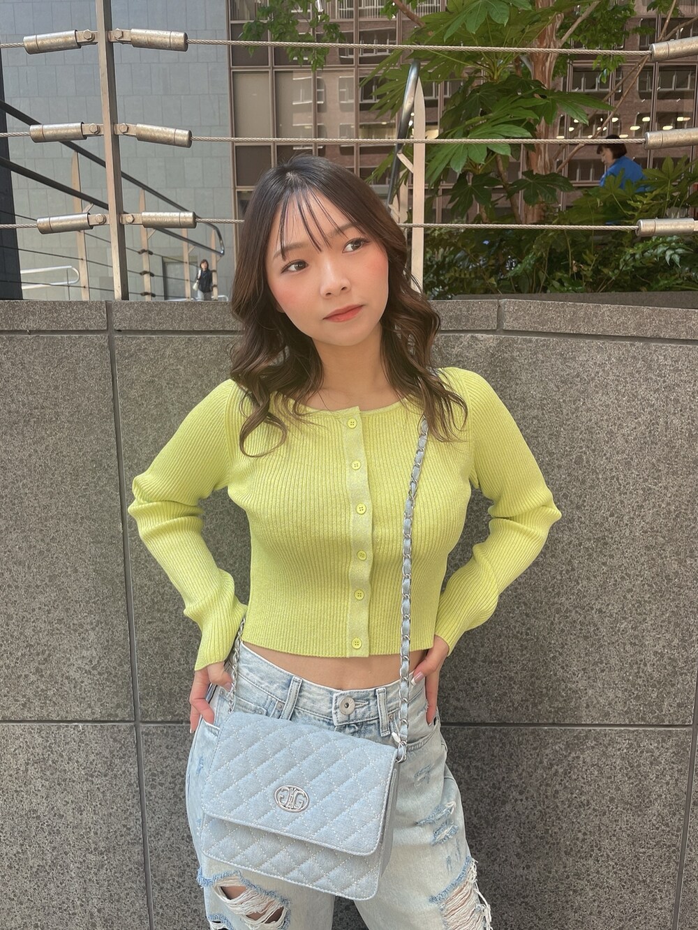 ブルー系のデニムパンツ、ホワイト系のサンダルを着用したレディースの春コーディネートの4枚目の写真