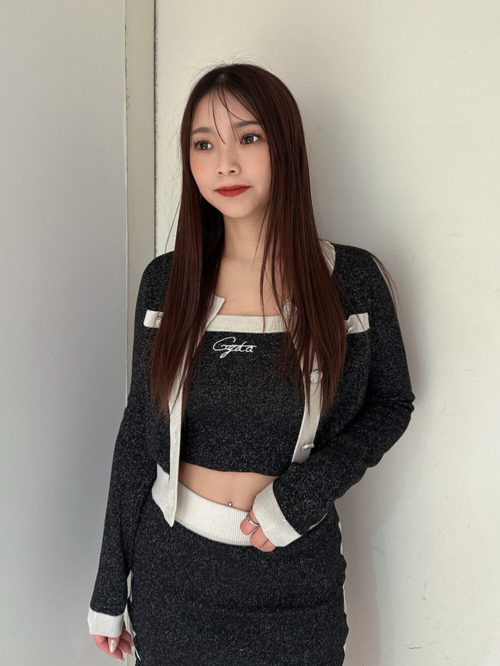 ブラック系のニット/セーター、ブラック系のスカート、ブラック系のブーツを着用したレディースの春コーディネートの4枚目の写真