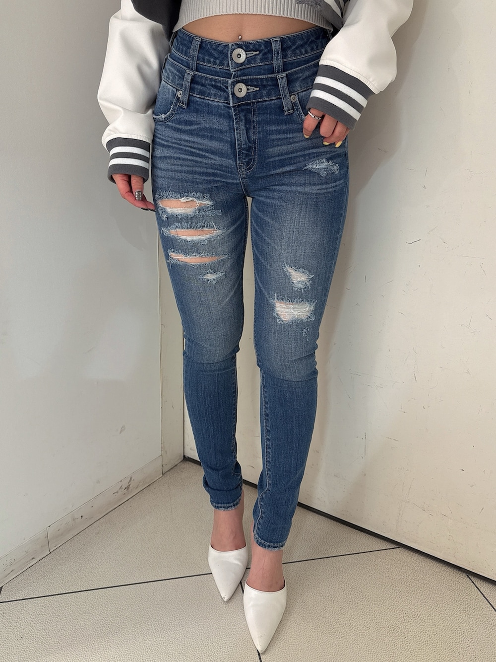 グレー系のニット/セーター、ブルー系のデニムパンツ、ホワイト系のパンプスを着用したレディースの冬コーディネートの8枚目の写真