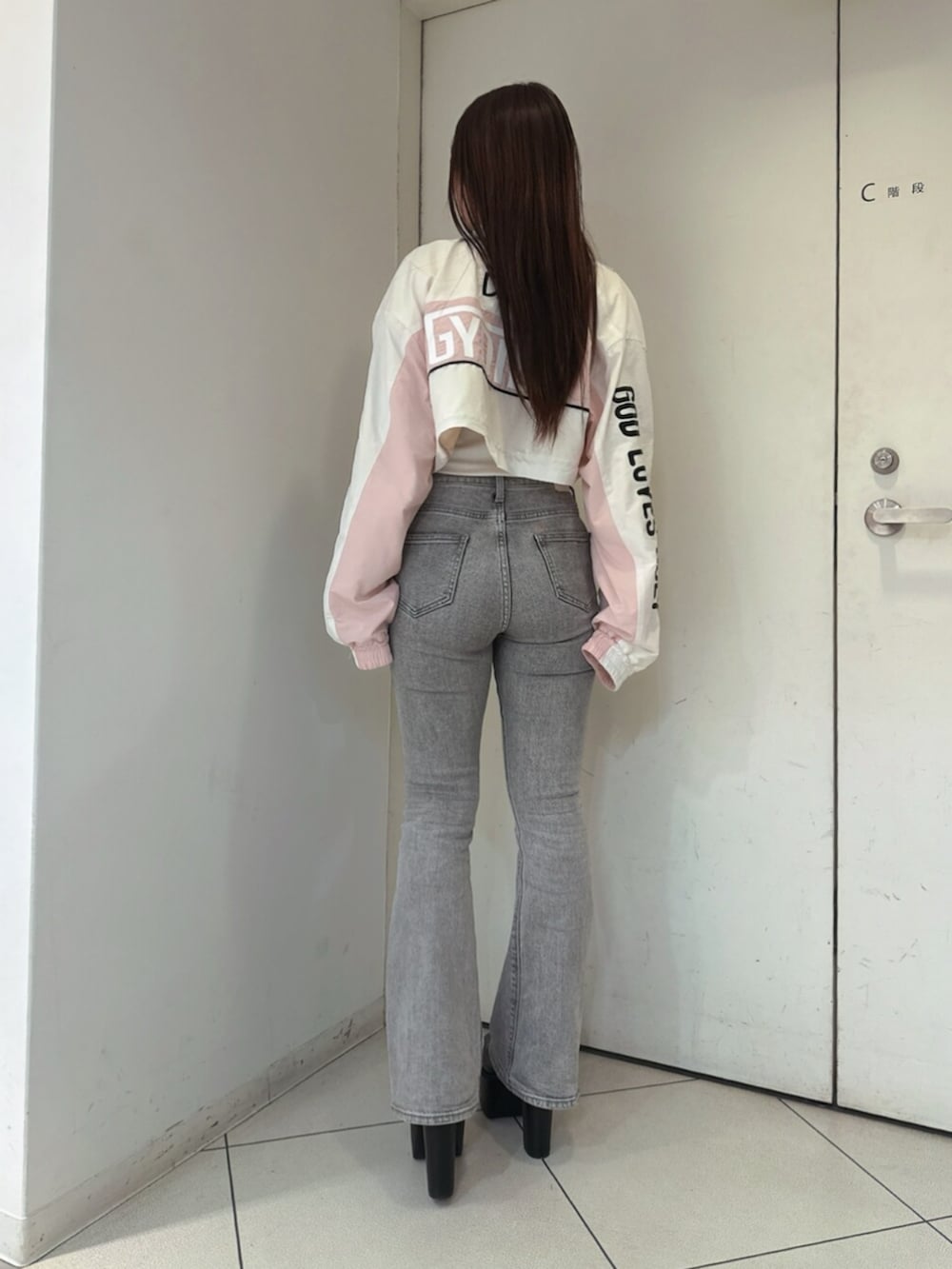 グレー系のデニムパンツ、ホワイト系のTシャツ/カットソー、ブラック系のブーツを着用したレディースの夏コーディネートの3枚目の写真