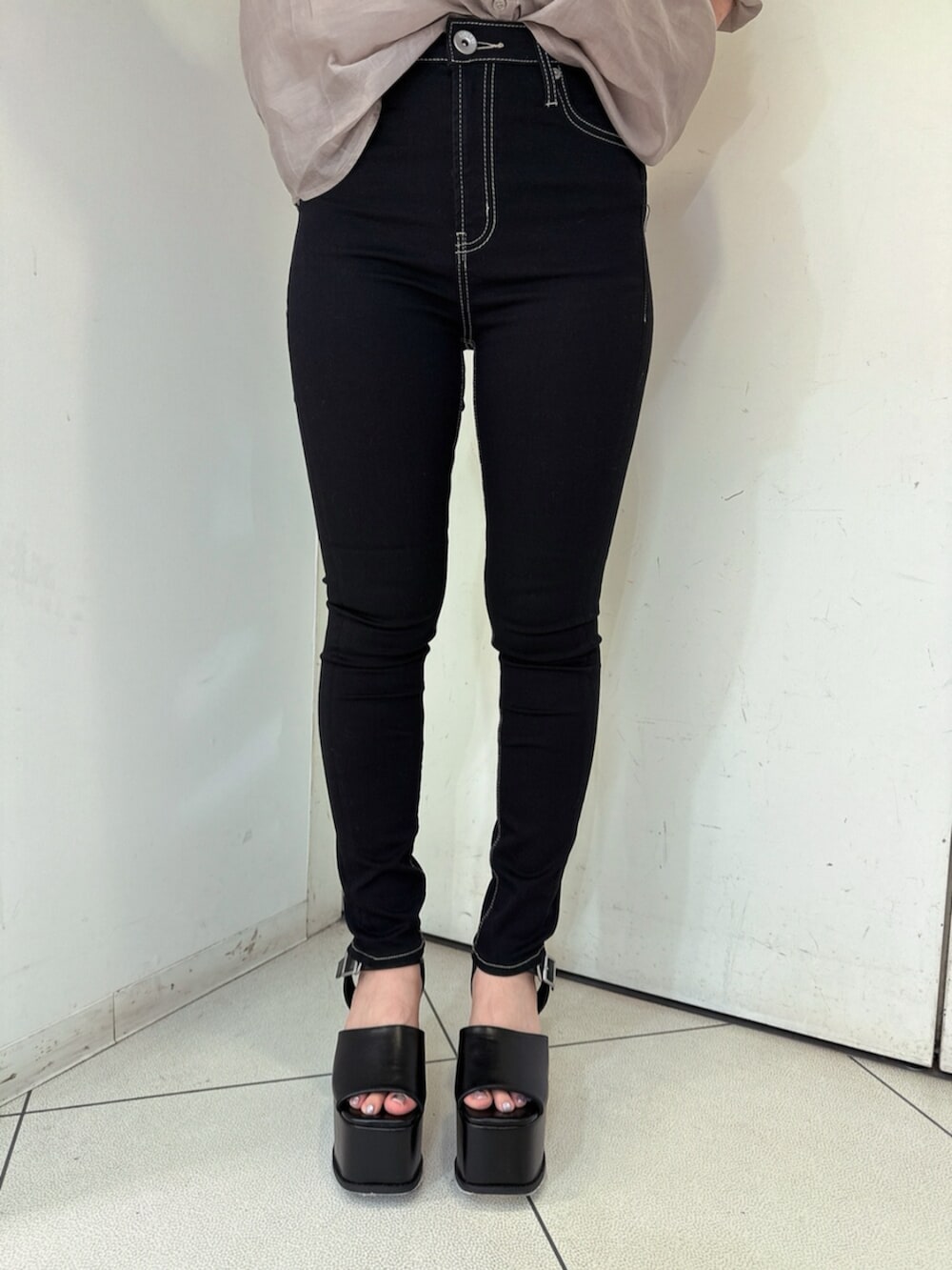 ブラック系のデニムパンツ、ブラック系のサンダル、ベージュ系のシャツ/ブラウスを着用したレディースの春コーディネートの8枚目の写真