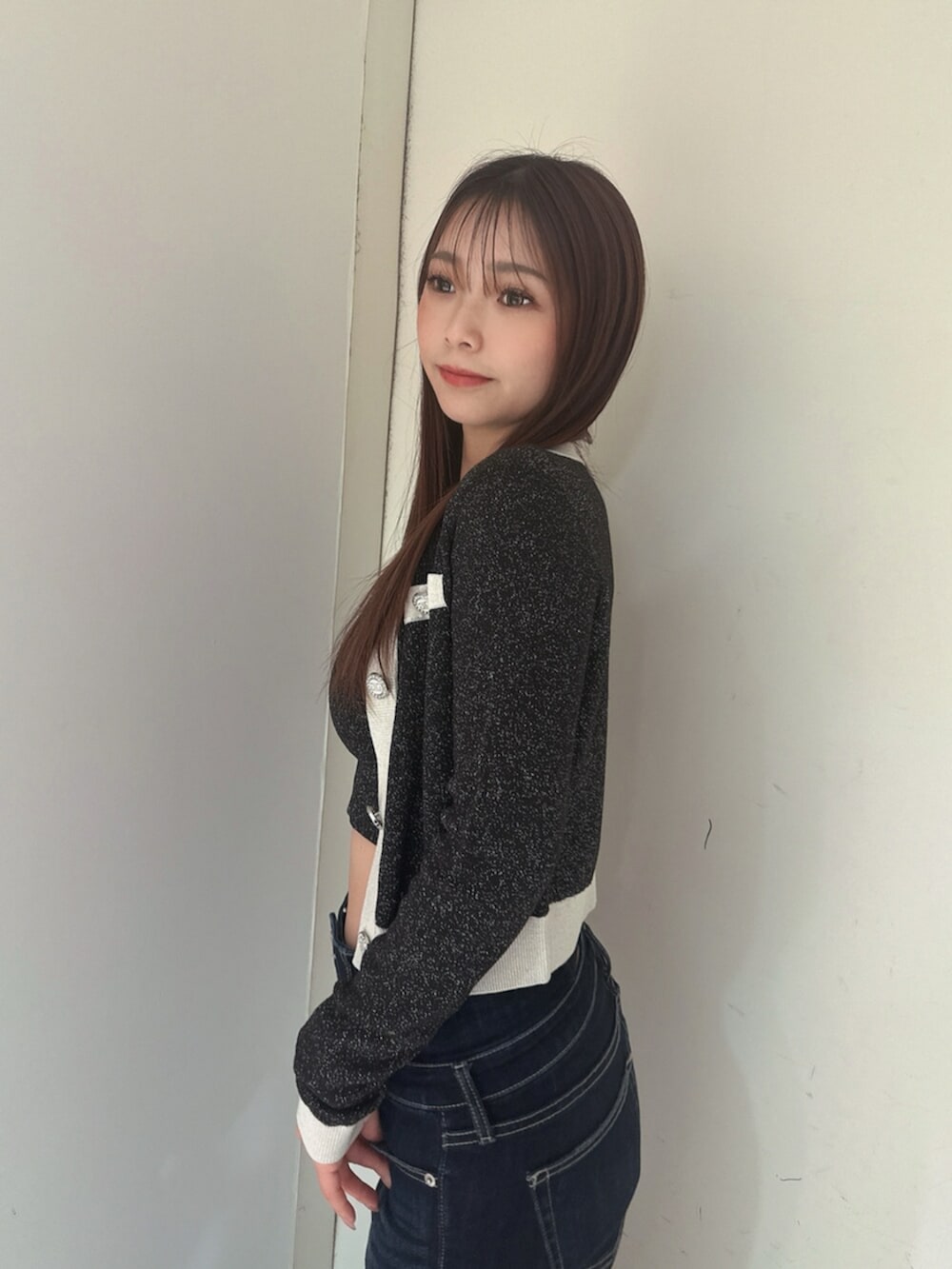 ブルー系のデニムパンツ、ブラック系のサンダル、ブラック系のニット/セーターを着用したレディースの春コーディネートの5枚目の写真