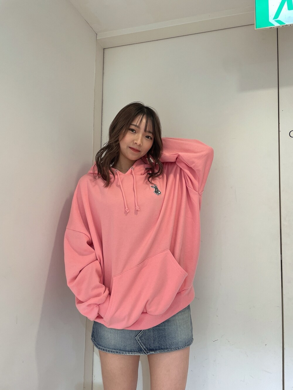 ピンク系のパーカー、ブルー系のデニムスカートを着用したレディースの冬コーディネートの3枚目の写真