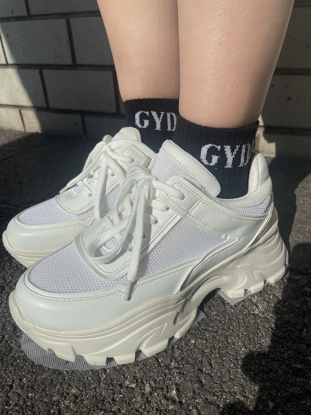 ブラック系のニット/セーター、ホワイト系のバックパック/リュック、ブルー系のデニムパンツを着用したレディースの冬コーディネートの8枚目の写真