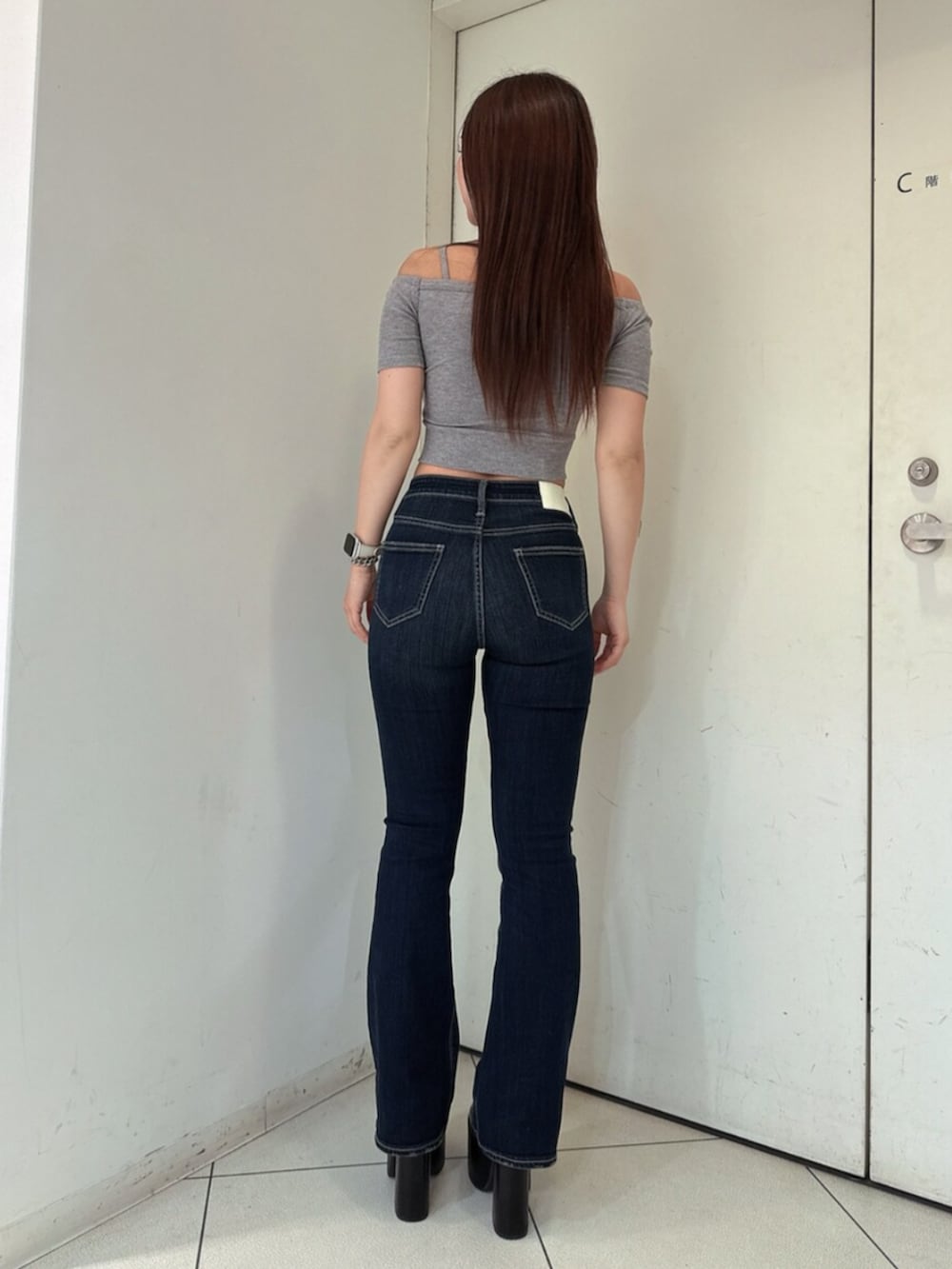 ブルー系のデニムパンツ、ブラック系のサンダル、グレー系のTシャツ/カットソーを着用したレディースの春コーディネートの3枚目の写真