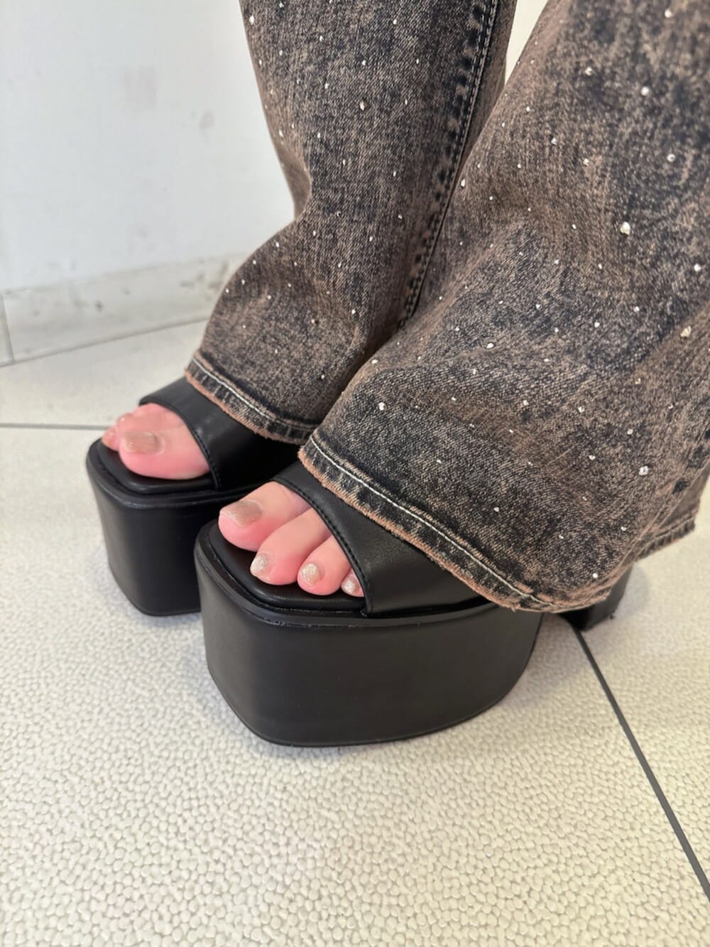 ブラック系のサンダル、ブルー系のデニムパンツ、ブラック系のタンクトップを着用したレディースの夏コーディネートの9枚目の写真