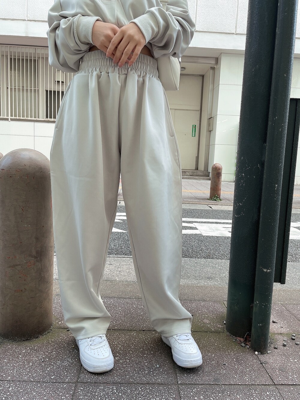 ホワイト系のスウェットパンツ、ホワイト系のハンドバッグ、ホワイト系のチューブトップを着用したレディースの冬コーディネートの5枚目の写真