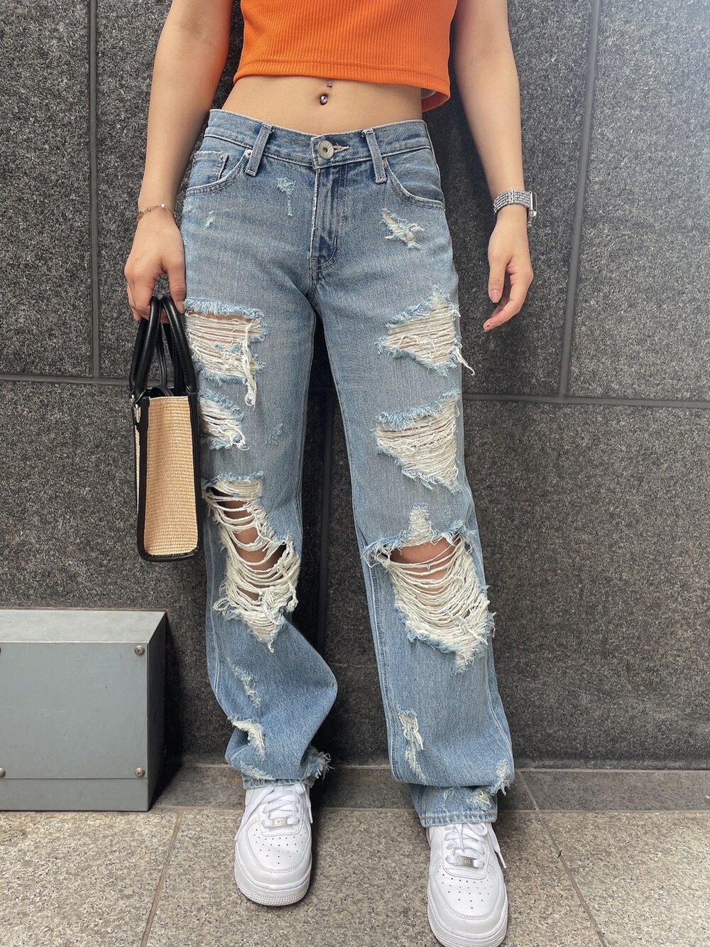 オレンジ系のTシャツ/カットソー、ブルー系のデニムパンツ、ブラック系のチューブトップを着用したレディースの夏コーディネートの6枚目の写真