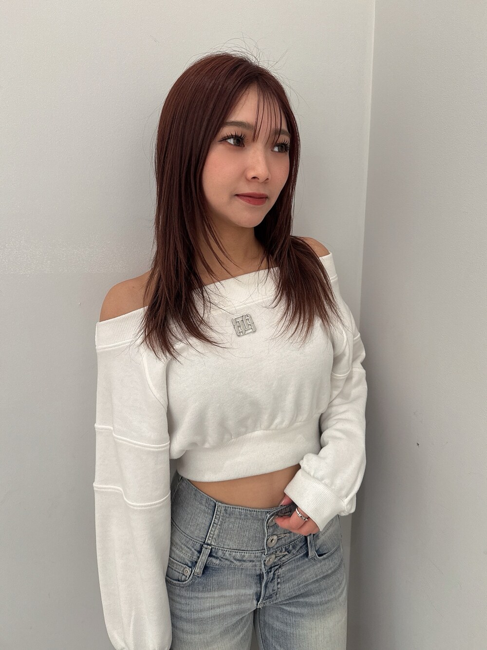 ブルー系のデニムパンツ、ホワイト系のパンプス、ホワイト系のスウェットを着用したレディースの冬コーディネートの4枚目の写真